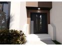 Contemporary front door with wood accents, white stairs, and stylish landscaping for a modern home entrance at 2360 Ocean Shore Blvd # 4, Ormond Beach, FL 32176