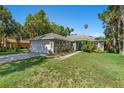 Inviting single-story home showcasing a two-car garage, lush lawn, and inviting front entryway at 2531 Needle Palm Dr, Edgewater, FL 32141