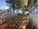 Fenced backyard providing privacy, bordered by mature trees and greenery, perfect for outdoor activities at 264 Sherwood Ln, Daytona Beach, FL 32117