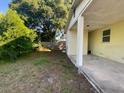 Spacious side yard with a view of the carport and a well-defined property line with a wooden fence at 264 Sherwood Ln, Daytona Beach, FL 32117
