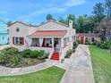 Charming single-story home featuring a beautiful red tile roof, covered porch, and meticulously maintained landscaping at 918 N Wild Olive Ave, Daytona Beach, FL 32118