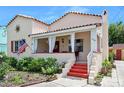 Charming single-story home featuring a beautiful red tile roof, covered porch with white curtains, and landscaping at 918 N Wild Olive Ave, Daytona Beach, FL 32118