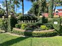 Welcoming Carmel entrance sign with lush greenery, brick accents, and clear blue sky at 1162 Carmel Cir # 100, Casselberry, FL 32707