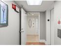 Hallway leading to unit entrance with a door featuring decorative glass and an elevator on the side at 1239 Ocean Shore Blvd # 3C3, Ormond Beach, FL 32176