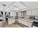 Well-lit kitchen with white cabinets, stainless steel appliances, and an adjacent dining area at 133 Blue Heron Dr # D, Daytona Beach, FL 32119