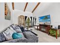 Cozy living room featuring vaulted ceilings, wooden beams, comfortable seating, and a decorative fireplace at 133 Blue Heron Dr # D, Daytona Beach, FL 32119
