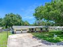 Charming single-story home with yellow siding, brick accents, well-manicured lawn, mature trees, and an attached two-car garage at 1505 Valencia Ave, Daytona Beach, FL 32117