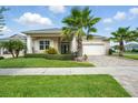 Attractive home with a lush front lawn, complemented by beautiful landscaping and a spacious two-car garage at 3048 Borassus Dr, New Smyrna Beach, FL 32168