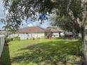 Large, well-maintained backyard with a white fence, green grass, and mature trees at 465 Dahoon Holly Dr, Daytona Beach, FL 32117
