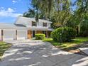 Inviting two-story home with a spacious driveway and well-manicured lawn surrounded by lush greenery at 506 Dorset Cir, South Daytona, FL 32119