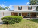 Charming two-story home featuring a welcoming front porch with brick accents and a well-maintained lawn at 506 Dorset Cir, South Daytona, FL 32119