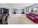 Spacious living room featuring plush carpeting, a large window, and a comfortable red leather sofa at 950 Pineapple Rd, South Daytona, FL 32119