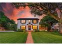 Beautiful two-story home with lush lawn and brick walkway leading to the entrance, illuminated by a vibrant sunset at 1221 Gamble Pl, Daytona Beach, FL 32118
