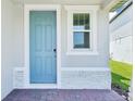 Close up on an inviting light blue front door with white trim and brick pavers at 288 Links Terrace Blvd, Daytona Beach, FL 32124