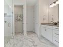 Bathroom with marble floors, walk-in shower, granite counter, and stylish wall mirror at 3029 Adrian Dr, Ormond Beach, FL 32174