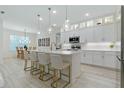 A bright kitchen features a quartz island with seating, complemented by white cabinetry and pendant lighting at 3029 Adrian Dr, Ormond Beach, FL 32174