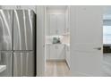 Butler's pantry featuring white cabinets, countertop, and view to the stainless steel refrigerator at 3029 Adrian Dr, Ormond Beach, FL 32174