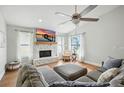 Bright living room features a stone fireplace, ceiling fan, and hardwood floors for a comfortable and stylish space at 920 N Lakewood Ter, Port Orange, FL 32127