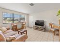 Cozy living room featuring natural light, tile floors, comfortable seating, and a small dining area at 1 Beechwood Dr, Ormond Beach, FL 32176