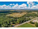 Aerial view showing a large lot of land with surrounding trees and fields at 1544 S Us 301, Sumterville, FL 33585