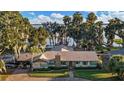 An estate home with mature landscaping, a private lake pier, and a lush green lawn at 1241 W Lakeshore Dr, Clermont, FL 34711