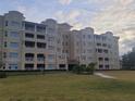 Tan multi-story building with balconies and landscaped grounds at 8495 Miracle Dr # 202, Champions Gate, FL 33896