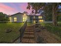 Lovely two-story home with a brick-laid path and manicured landscaping illuminated at dusk at 1635 Hilltop Dr, Mount Dora, FL 32757