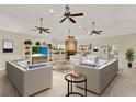 Bright living room with a stone fireplace, built-in shelves, and multiple ceiling fans at 23321 N Buckhill Rd, Howey In The Hills, FL 34737