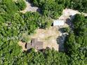 Expansive property featuring a house and large outbuilding surrounded by dense, mature trees offering privacy at 1921 Smitty Rd, Lady Lake, FL 32159