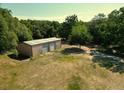 Large metal outbuilding with multiple roll-up doors, providing ample storage or workspace on the property at 1921 Smitty Rd, Lady Lake, FL 32159