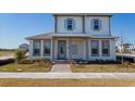 Two-story home with light-gray siding, blue shutters, and a metal roof at 10125 Gobat Aly, Orlando, FL 32827