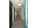 Inviting foyer featuring wood-look tile flooring, contemporary lighting, and a stylish barn door accent at 10218 Dulbecco St, Orlando, FL 32827