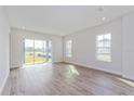 Spacious living room with wood-look tile floors and sliding glass doors at 10260 Medawar St, Orlando, FL 32827