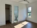 Light-filled bedroom with wood floors and en-suite bathroom at 16122 Pendio Dr, Bella Collina, FL 34756
