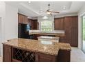 Eat-in kitchen with granite island, wine rack, and ample cabinet space at 16984 Se 109Th Ave, Summerfield, FL 34491