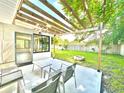 Charming patio area with pergola, outdoor seating, and fire pit, perfect for entertaining in the backyard at 14598 Sw 34Th Terrace Rd, Ocala, FL 34473