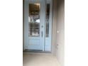 A light blue front door with glass panes and a silver handle at 2252 Juniper Berry Dr, Minneola, FL 34715