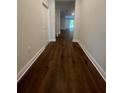 Hallway featuring wood-look floors and white trim with doors along the hall at 2252 Juniper Berry Dr, Minneola, FL 34715