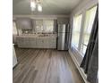 A kitchen featuring gray cabinets, stainless steel appliances, and wood-look flooring at 1010 S Grove St, Eustis, FL 32726