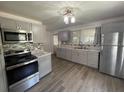 Bright kitchen featuring gray cabinets, stainless steel appliances, and tile backsplash at 1010 S Grove St, Eustis, FL 32726