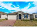 Curb appeal with gray siding, blue door, and brick driveway at 5807 Wallis Ln, Saint Cloud, FL 34771