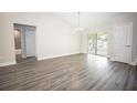 Open concept dining space featuring sliding glass doors, gray wood-look floors, and neutral paint at 8878 Se 158Th St, Summerfield, FL 34491