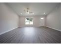 Spacious living room with gray wood-look floors, recessed lights, and a ceiling fan at 8878 Se 158Th St, Summerfield, FL 34491