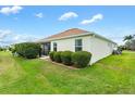 View of the house's side, showing a screened patio and hedges at 3732 Barrel Loop, The Villages, FL 32163