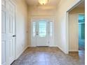 Bright entryway with tile floors, a decorative front door with sidelights, and a glimpse into the home's interior at 1338 Neuport Path, The Villages, FL 32163