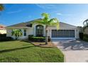 Charming home featuring mature landscaping, a pristine lawn, and a wide driveway leading to a spacious three-car garage at 1338 Neuport Path, The Villages, FL 32163