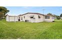View of the back of the house and large yard at 1209 Apache Cir, Tavares, FL 32778