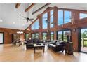 Open living room boasts hardwood floors, vaulted wood ceilings, and large windows with beautiful outdoor views at 26348 Se Highway 42, Umatilla, FL 32784