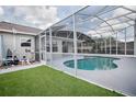 Backyard featuring screened-in pool with outdoor equipment and lush landscaping at 3114 Jemima Ave, The Villages, FL 32163