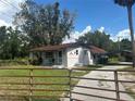 Charming single-story home with a well-maintained lawn and gated driveway at 11635 Se Highway 42, Weirsdale, FL 32195